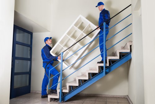 Moving team carrying boxes through a narrow staircase in Dulwich